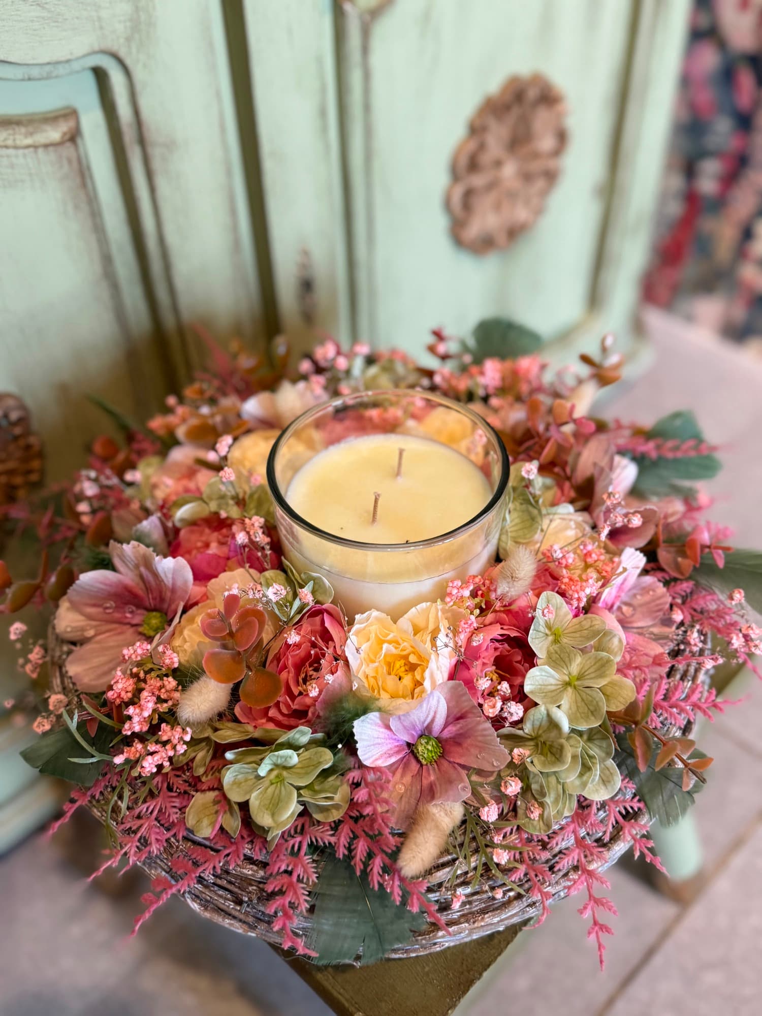 A candle wrapped in a small floral arrangement