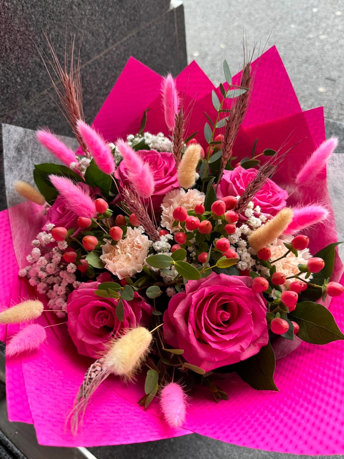 A bouquet of vivid pink gerberas against a pink backdrop