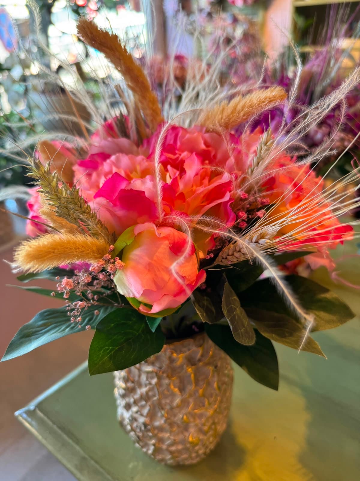 Dried grasses and flowers in a gold vase